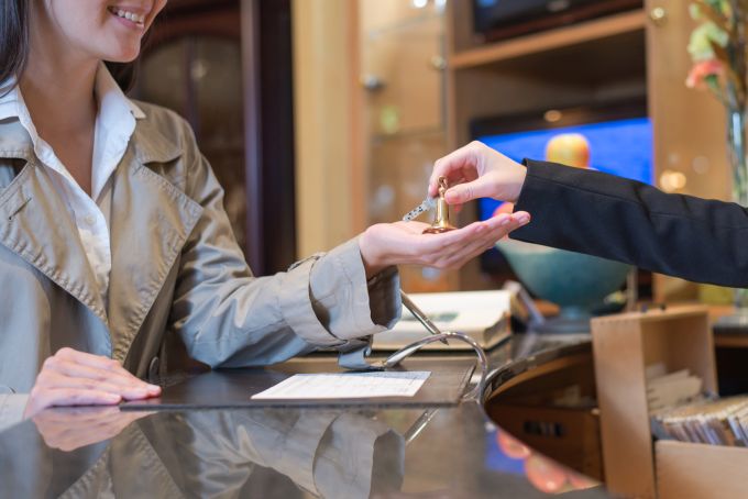 receptionist handing over keys to hotel room